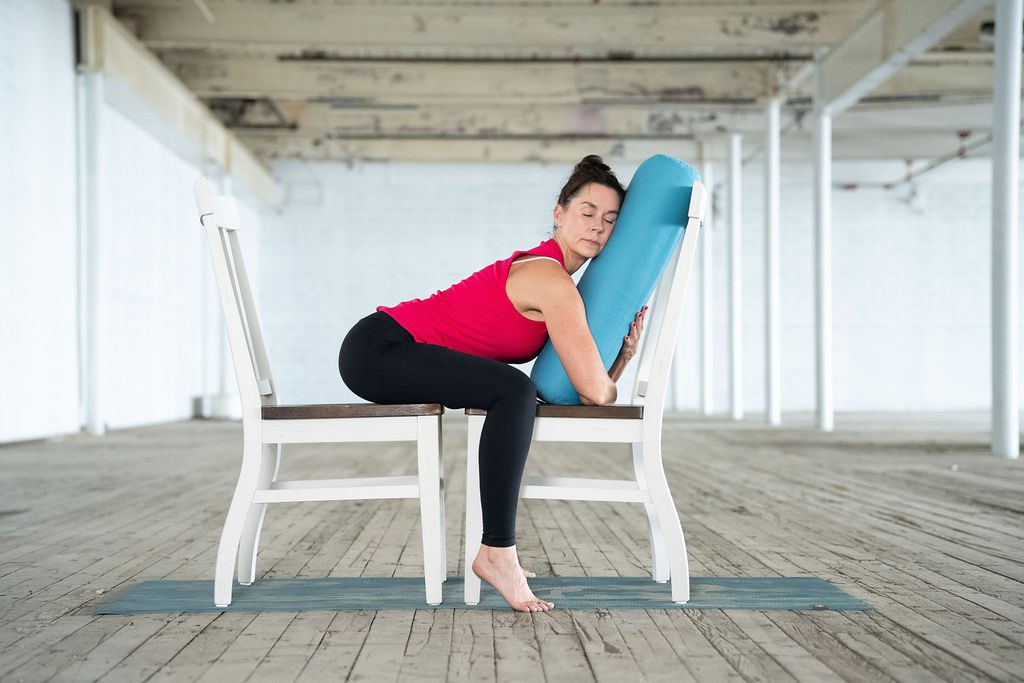 Jane practices an adaptive yoga session in Greenville, SC using two chairs and a yoga bolster for support