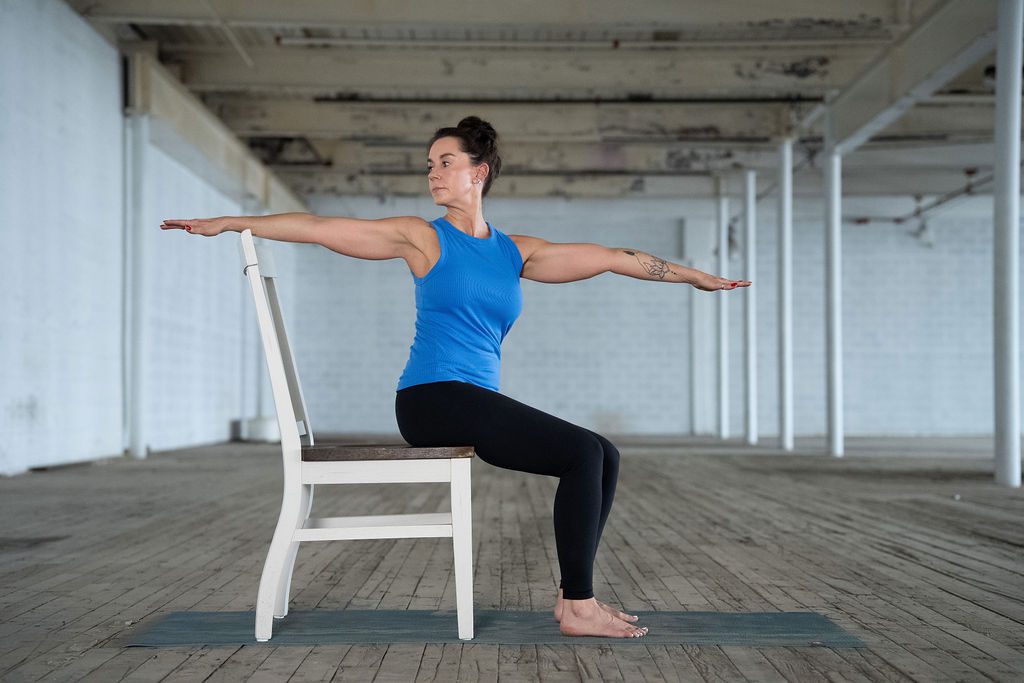 Jane Hart, Greenville-based Adaptive Yoga instructor does a modified warrior pose in a chair