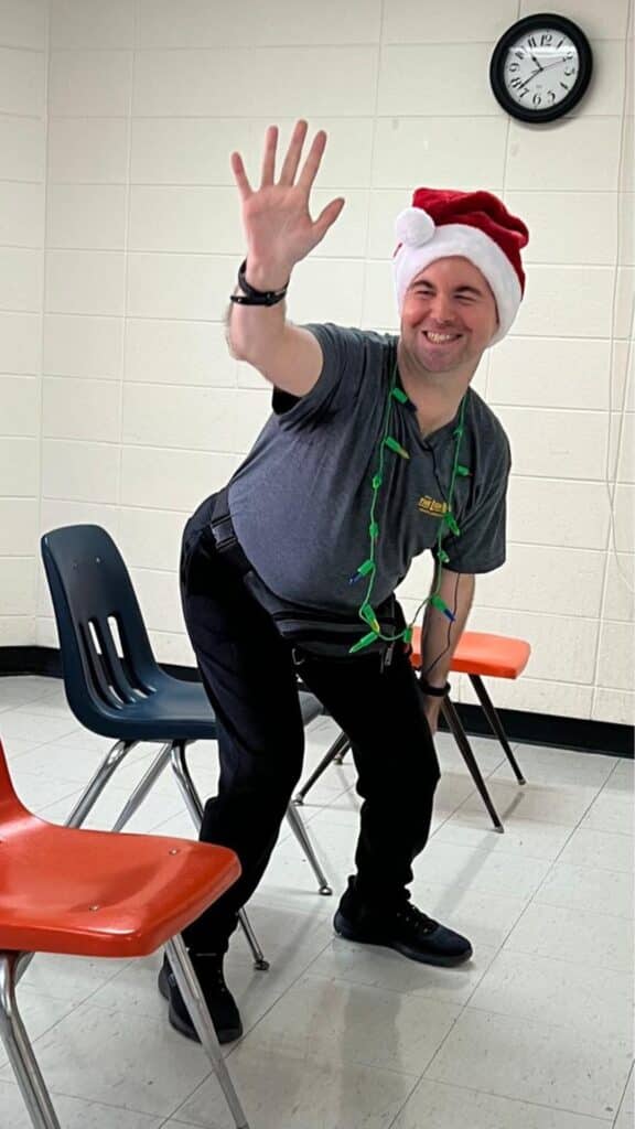 happy male student shares a high-five with yoga instructor jane hart after doing chair yoga at the adult day center