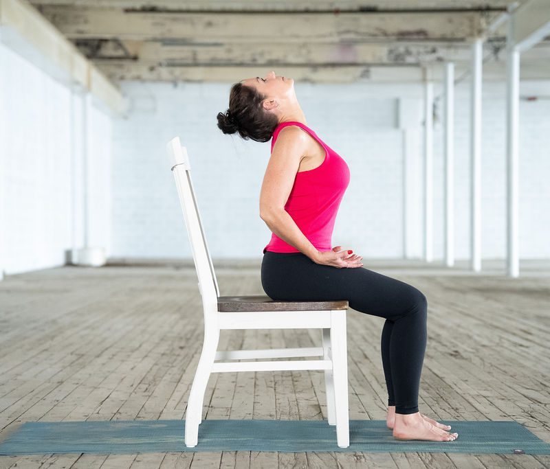 Modified Ability Yoga Instructor Jane Hart of Greenville, SC shows a cat cow adapted pose in a chair